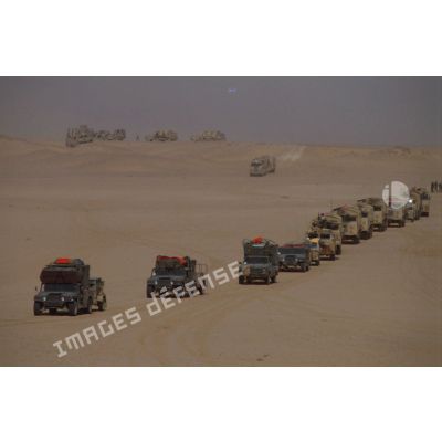 Des Hummer américains et des camions GBC 8KT en convoi dans le désert.