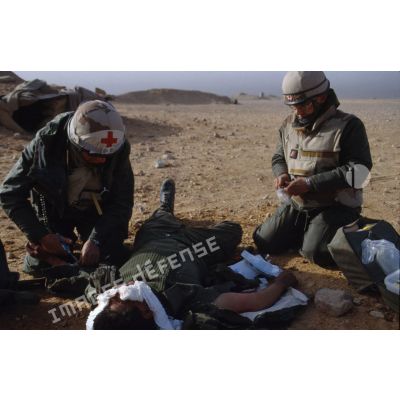 Un médecin du 3e RIMa (régiment d'infanterie de marine) soigne, sur le champ de bataille, un soldat irakien blessé au crâne et aux bras.