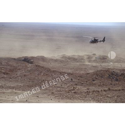 Survol par un hélicoptère Gazelle d'une position fortifiée irakienne, d'un char de combat T-55 et d'un transport de troupes chenillé MT-LB irakiens détruits dans la zone de Rochambeau.