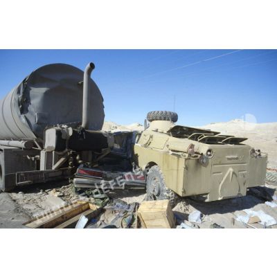 Blindés et camions irakiens détruits ou abandonnés à la sortie de Koweit City : un blindé de reconnaissance BRDM-2, une voiture et un camion-citerne encastrés.