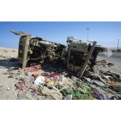 Epaves de camions irakiens détruits à la sortie de Koweit City, au milieu de tissus jonchant le sol.