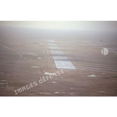 Vue aérienne de la piste détruite de  la base aérienne d'Al Salman avec des impacts et traces d'explosions.