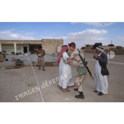 Un soldat américain des forces spéciales aux affaires civiles fouille un civil irakien dans une rue d'Al Salman.