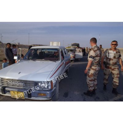Des prévôts français et des soldats américains refoulent des réfugiés irakiens arrivant en voiture qui ne résident pas à Al Salman à l'entrée de la ville.