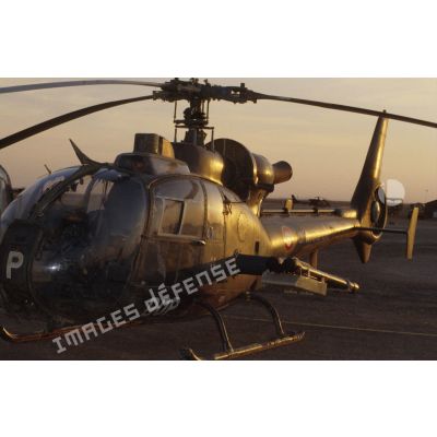 Au soir un hélicoptère de combat Gazelle Atam armé de missiles Mistral au sol dans le désert.