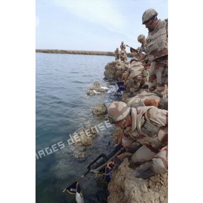Lors de la cérémonie militaire franco-américaine sur les bords du fleuve Euphrate, des militaires français trempent dans l'eau les fanions de leurs unités.