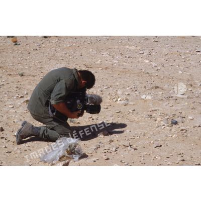Sur le bord de l'Euphrate, le brigadier caméraman de l'ECPA (Etablissement cinématographique et photographique des Armées), caméra à terre, effectue un gros plan.
