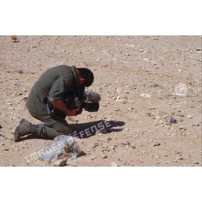 Sur le bord de l'Euphrate, le brigadier caméraman de l'ECPA (Etablissement cinématographique et photographique des Armées), caméra à terre, effectue un gros plan.