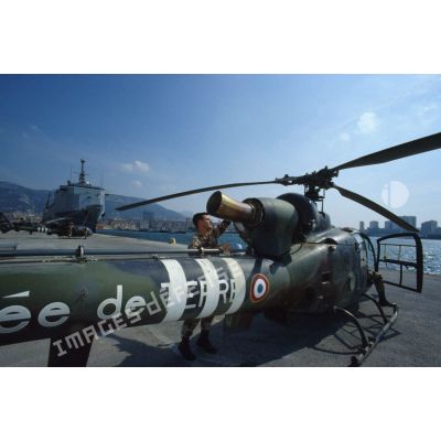 Au port de Toulon, un mécanicien du 3e RHC (régiment d'hélicoptères de combat) s'affaire sur la turbine d'un hélicoptère de combat Gazelle déchargé du TCD (transport de chalands de débarquement) Foudre amarré au quai.