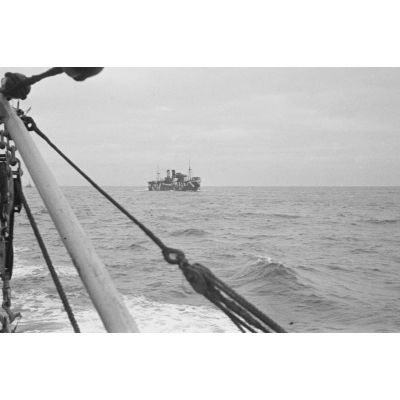 Lors d'une patrouille en mer à bord d'un dragueur de mines, un briseur de blocus (Sperrbrecher) orné d'un camouflage peint sur sa coque.