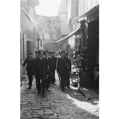 Des marins allemands de la Kriegsmarine débutent l'ascension des rues du Mont-Saint-Michel.