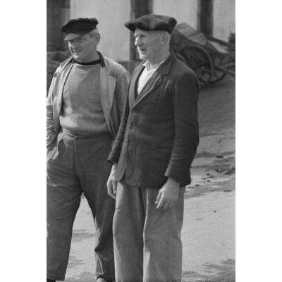 Deux hommes dont un vieillard observent le retour de la pêche dans le port de Douarnenez.