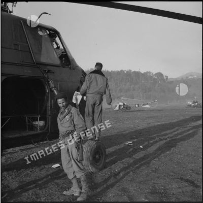 Un soldat pose devant un hélicoptère de transport lors d'une opération héliportée près de Tablat.