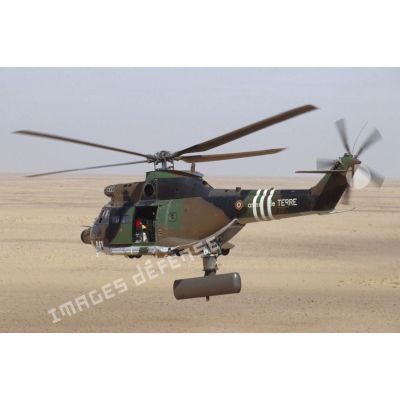 Un hélicoptère de transport Puma Orchidée (observatoire radar cohérent héliporté d'investigation des éléments ennemis) survole le désert saoudien.
