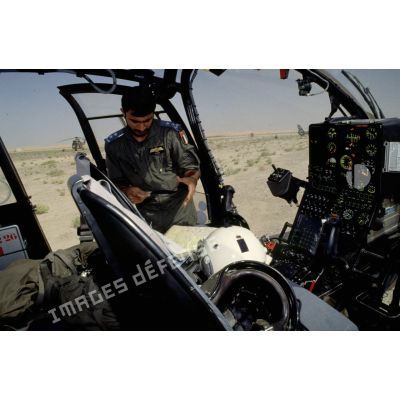 Pilote émirati au sol étudiant la carte dans son hélicoptère de combat Gazelle.