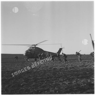 Un commando parachutiste de l'Air se dirige vers un hélicoptère.