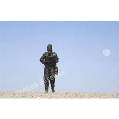 Soldat armé d'un fusil d'assaut FAMAS en tenue complète S-3P (survêtement de protection à port permanent) pour un entraînement NBC.