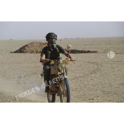 Soldat muni d'un ANP (appareil normal de protection) à visière panoramique modèle F1 sur une motocyclette Peugeot 80 cm3.