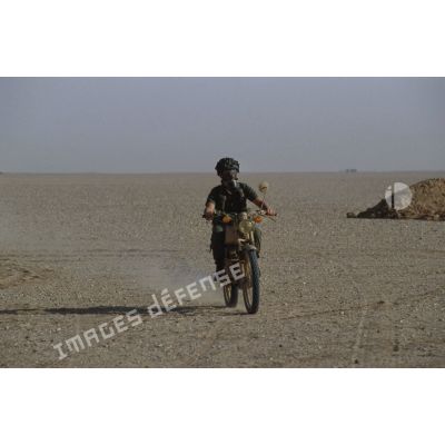 Soldat muni d'un ANP (appareil normal de protection) à visière panoramique modèle F1 sur une motocyclette Peugeot 80 cm3.