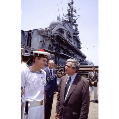 Jean-Pierre Chevènement, ministre de la Défense, en conversation avec un marin du PA (porte-avions) Clemenceau, sur le quai à Djibouti.