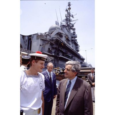 Jean-Pierre Chevènement, ministre de la Défense, en conversation avec un marin du PA (porte-avions) Clemenceau, sur le quai à Djibouti.