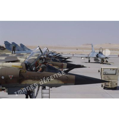 Sur la BA (base aérienne) d'Al Ahsa, des avions de combat Mirage F1-CR sont alignés, des Mirage 2000 à l'arrière-plan.