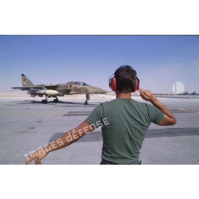 Sur la BA (base aérienne) d'Al Ahsa, guidage sur la piste au retour de mission d'un avion de combat Jaguar.