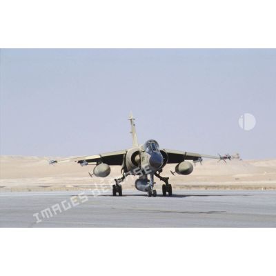 Un avion de combat Mirage F1-CR, armé de missiles Matra R-550 Magic II en bout d'ailes s'avance sur la piste de la BA (base aérienne) d'Al Ahsa.