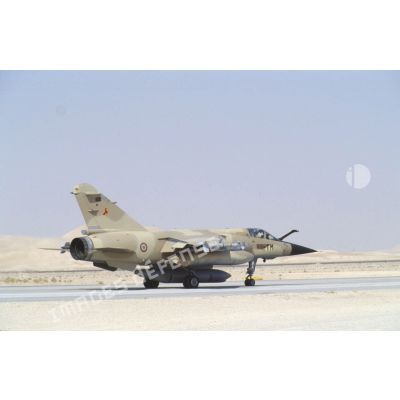 Un avion de combat Mirage F1-CR de l'ER (escadron de reconnaissance) 2/33 Savoie (cocotte), armé de missiles Matra R-550 Magic II en bout d'ailes, s'avance sur la piste de la BA (base aérienne) d'Al Ahsa.