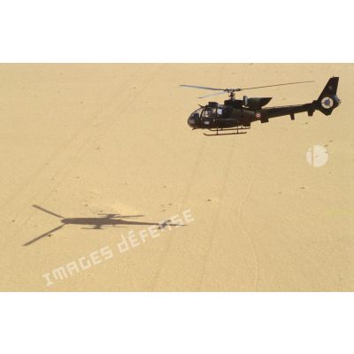 Un hélicoptère de combat Gazelle Hot du 5e RHC survole le désert.
