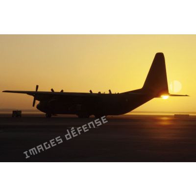 Coucher de soleil sur l'aéroport de CRK (camp du roi Khaled) et un avion de transport Hercules C-130.