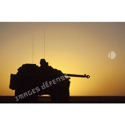 Blindé de reconnaissance AMX-10 RC sur le pas de tir en contre-jour au coucher du soleil.