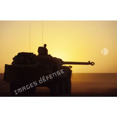 Blindé de reconnaissance AMX-10 RC sur le pas de tir en contre-jour au coucher du soleil.