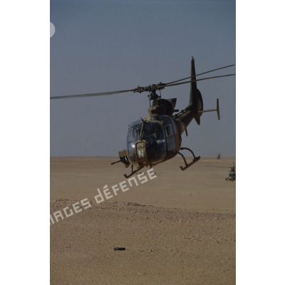 Un hélicoptère de combat Gazelle Canon du 5e RHC, équipée de son canon de 20 mm, effectue un vol de reconnaissance dans le désert.