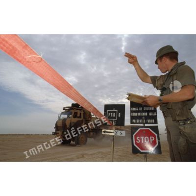Au poste de régulation de la circulation routière à l'entrée de CRK (camp du roi Khaled), un soldat fait signe au chauffeur d'un camion TRM-4000 d'avancer.