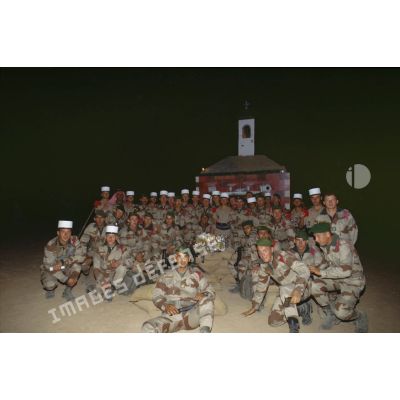 Photographie de groupe des légionnaires devant la crèche de Noël de la 2e section, 2e compagnie du 2e REI.