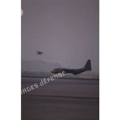 Un avion de combat Jaguar à l'atterrissage à proximité d'un avion de transport Hercules C-130 sur le taxiway de la BA (base aérienne) d'Al Ahsa.