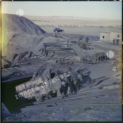 Un groupe d'hommes à l'entrée d'une mine souterraine.