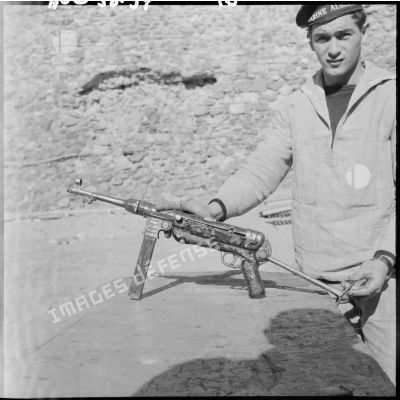 Un marin tenant un pistolet mitrailleur.