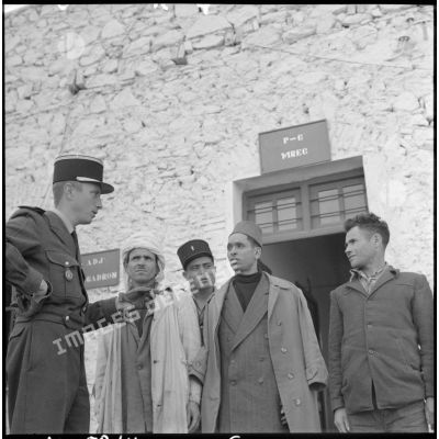 Un officier français discute avec trois harkis lors de leur engagement à Bou-Saâda.