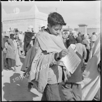 Un jeune garçon lit un tract à Bou-Saâda.