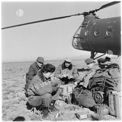 Un groupe de parachutistes devant leur hélicoptère.