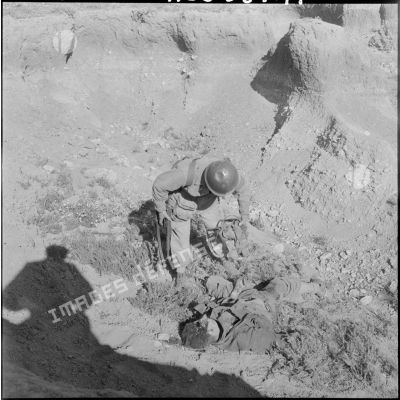 Un soldat du 81ème régiment d'infanterie (RI) près du corps du fellaga qu'il vient de tuer.