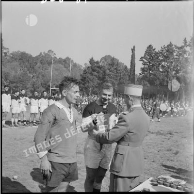 Un officier remet le fanion du champion inter-armées de rugby d'Afrique du Nord lors d'une compétition.