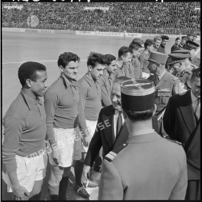 Le ministre Robert Lacoste, accompagné d'officiers, salue les joueurs avant une rencontre de football France-Belgique en Algérie.