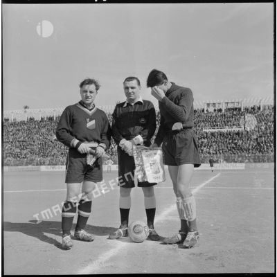 Les capitaines des équipes de football et l'arbitre avant une rencontre France-Belgique en Algérie.