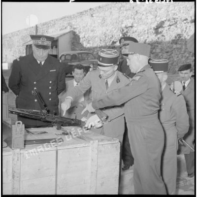 Le général Salan inspectant une cargaison d'armes, ici une mitrailleuse allemande MG 42.