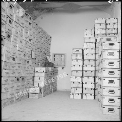 Caisses de munitions entassées dans un entrepôt.
