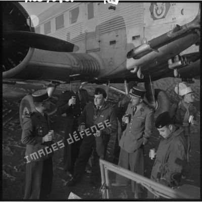 Pilotes et légionnaires boivent devant l'avion de transport Junkers Ju-52.