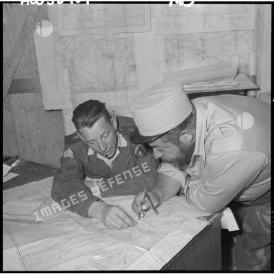 Deux légionnaires à leur bureau travaillant sur une carte.